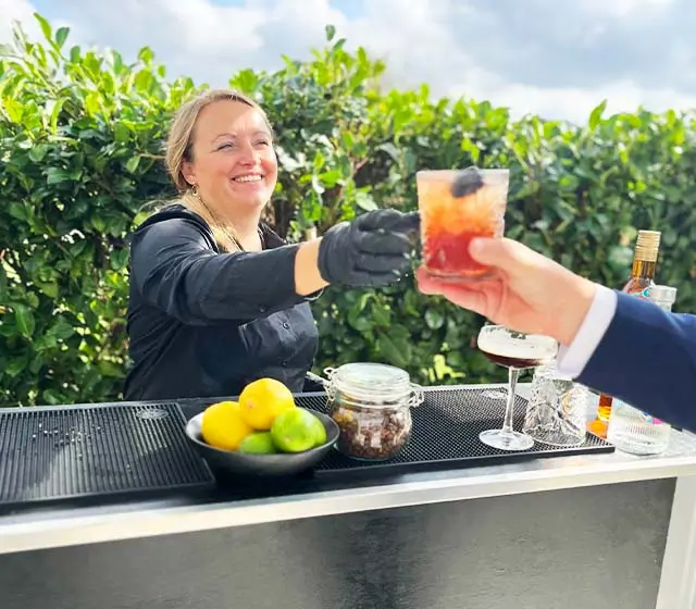 Bartender giver kunde en bramble cocktail