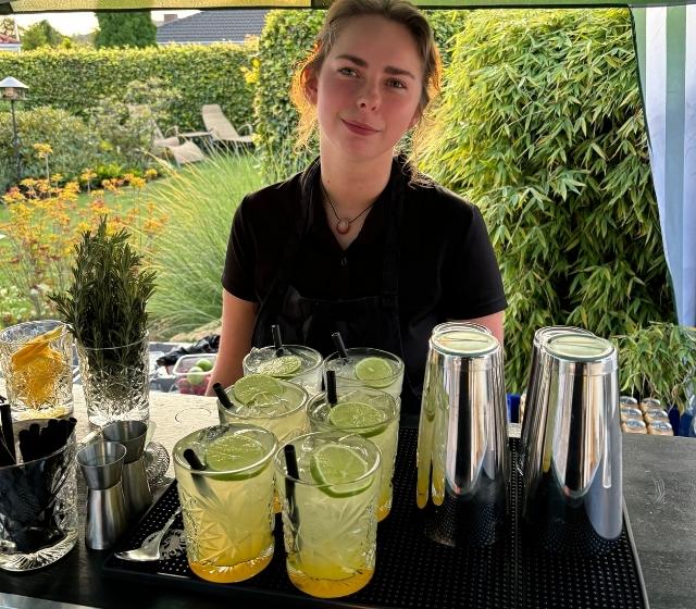 sommerbar Bartender giver kunde en bramble cocktail